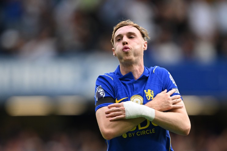 Footballer in blue jersey with bandaged arm, celebrating on field.