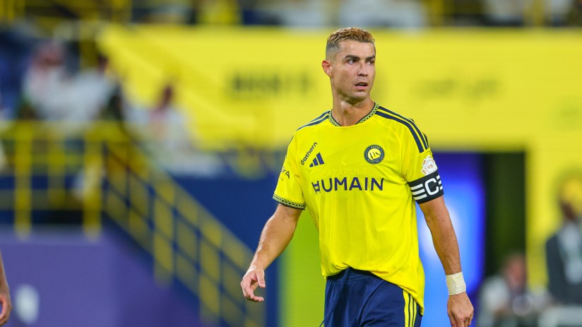 Cristiano Ronaldo in a yellow Al Nassr FC jersey on a soccer field