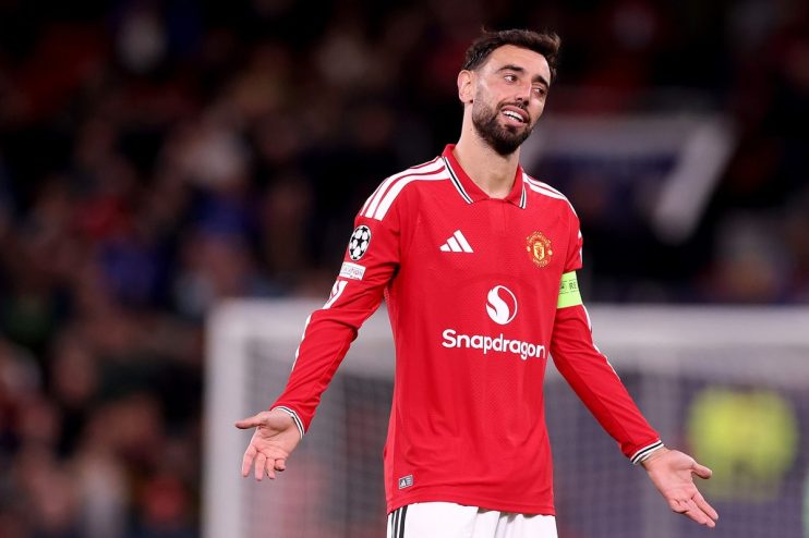 Bruno Fernandes in a red Manchester United jersey, shrugging with open palms on a soccer field