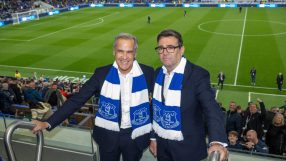 Two men in suits and Everton FC scarves smiling at a football stadium.