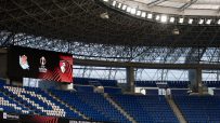 Empty stadium seating with UEFA Europa League logos on a large screen and Swissquote branding.