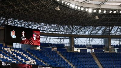 Empty stadium seating with UEFA Europa League logos on a large screen and Swissquote branding.