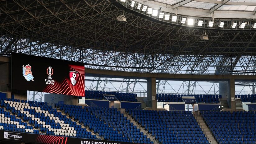 Empty stadium seating with UEFA Europa League logos on a large screen and Swissquote branding.