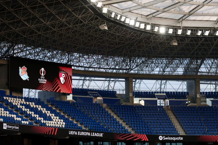 Empty stadium seating with UEFA Europa League logos on a large screen and Swissquote branding.