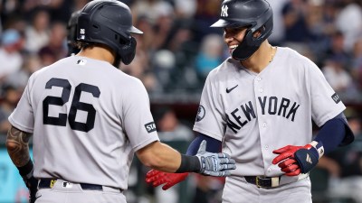 New York Yankees players celebrating on the field, one wearing number 26, the other smiling.
