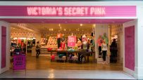 Victorias Secret Pink store entrance with mannequins, merchandise, and a Free Beach Blanket sign.