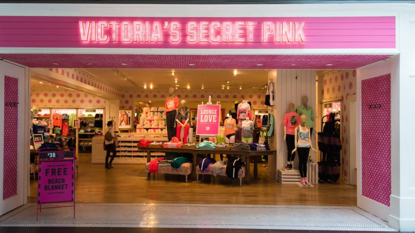 Victorias Secret Pink store entrance with mannequins, merchandise, and a Free Beach Blanket sign.