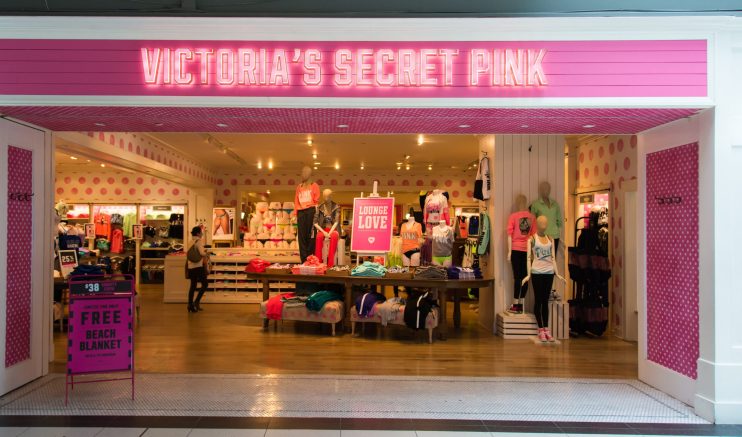 Victorias Secret Pink store entrance with mannequins, merchandise, and a Free Beach Blanket sign.