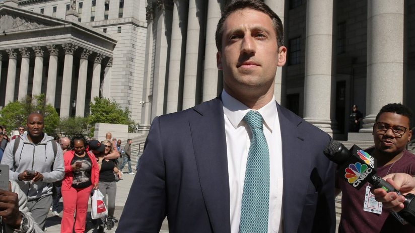 Man in a suit and tie speaks into a CNBC microphone outside a courthouse with large columns.