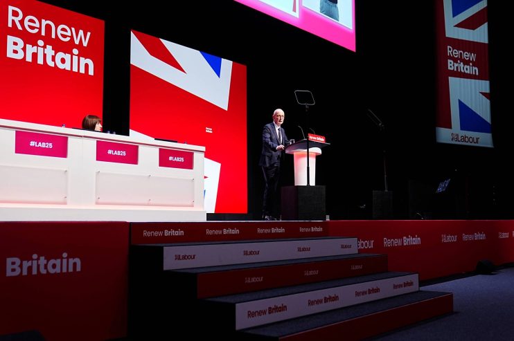 Keir Starmer speaking at a Labour Party conference with Renew Britain banners and Union Jack design