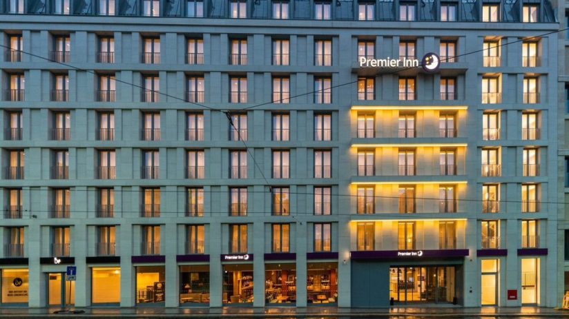 Premier Inn hotel building in Leipzig, Germany, at dusk with illuminated windows and ground floor businesses