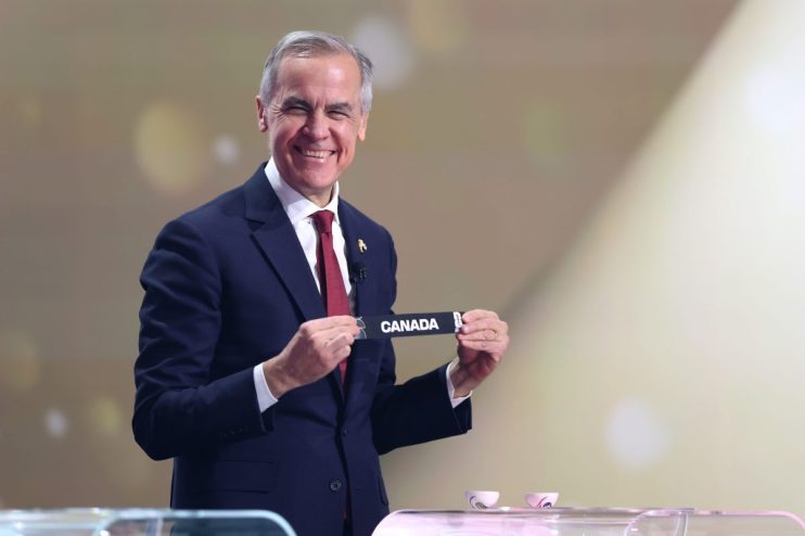 Mark Carney, former Bank of Canada Governor, smiling and holding up a CANADA sign.