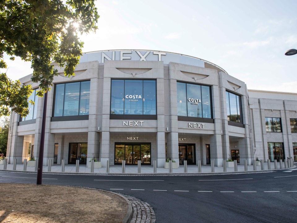 NEXT store at Bluewater, Kent, with Costa Coffee branding visible in the windows, sunny day