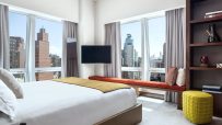 Luxurious bedroom at The Langham New York hotel with city views, modern furniture, and large windows