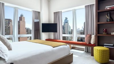 Luxurious bedroom at The Langham New York hotel with city views, modern furniture, and large windows