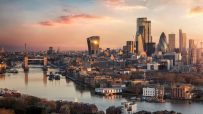 London skyline at sunset with Tower Bridge, River Thames, and modern financial district buildings