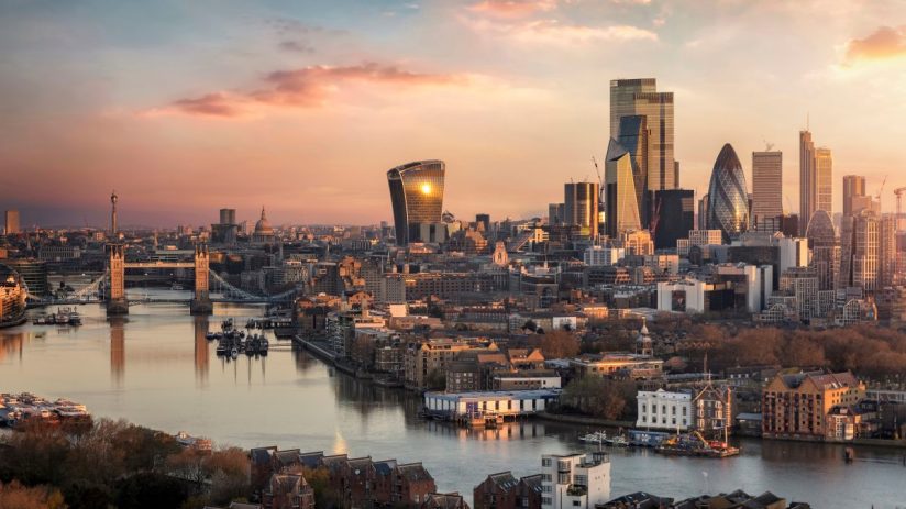 London skyline at sunset with Tower Bridge, River Thames, and modern financial district buildings