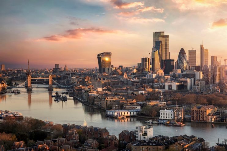 London skyline at sunset with Tower Bridge, River Thames, and modern financial district buildings