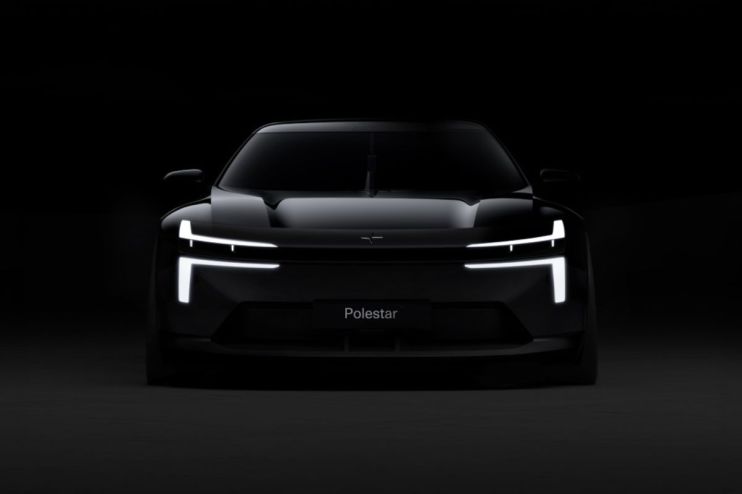 Front view of the dark Polestar electric vehicle with illuminated LED headlights and the Polestar logo.