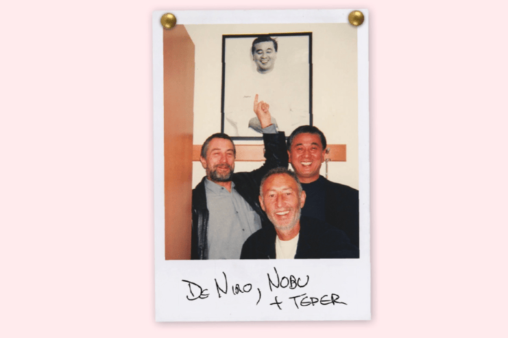 Robert De Niro, Nobu Matsuhisa, and Meir Teper smiling in a Polaroid, with a framed picture in background