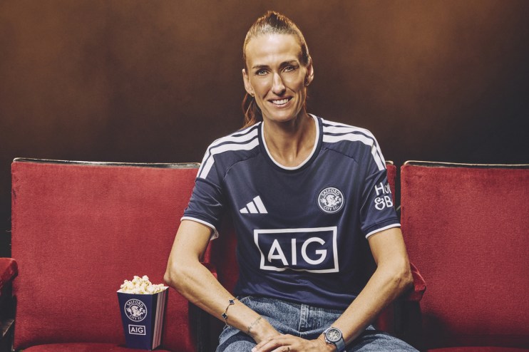 Jill Scott in Salford City FC kit, smiling, sitting on a red seat with popcorn.