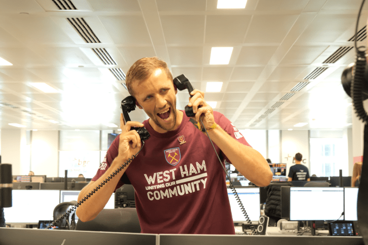 Tom&aacute;&scaron; Souček in West Ham United shirt excitedly holding two phone receivers at the BGC Charity Day