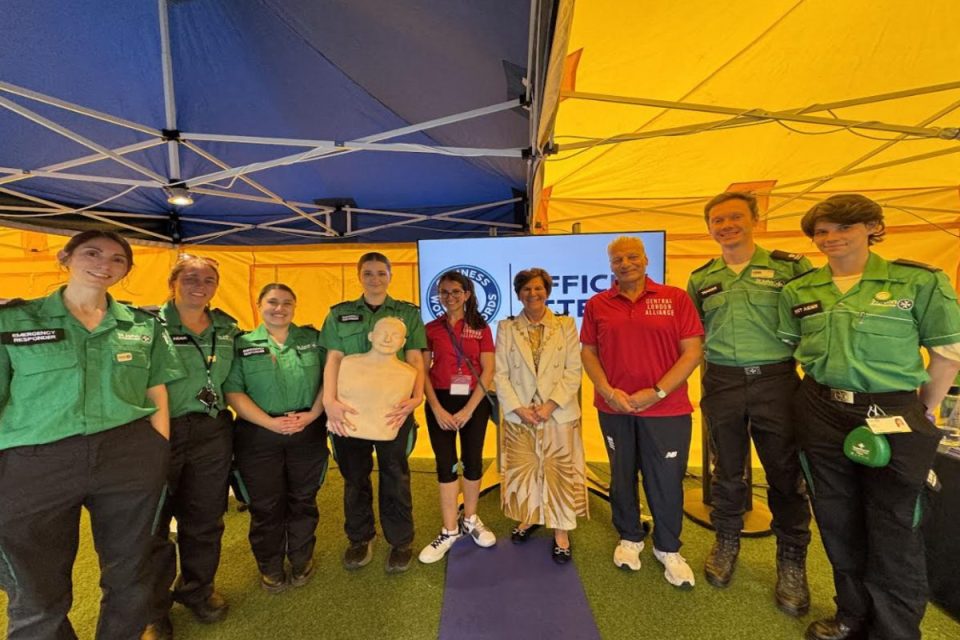 Group of emergency responders and community members at a first aid training event under a tent.