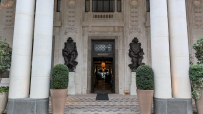 Grand entrance of Six Senses London, featuring large pillars, ornate sculptures, and a WHITELEYS sign above the door.