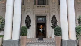 Grand entrance of Six Senses London, featuring large pillars, ornate sculptures, and a WHITELEYS sign above the door.
