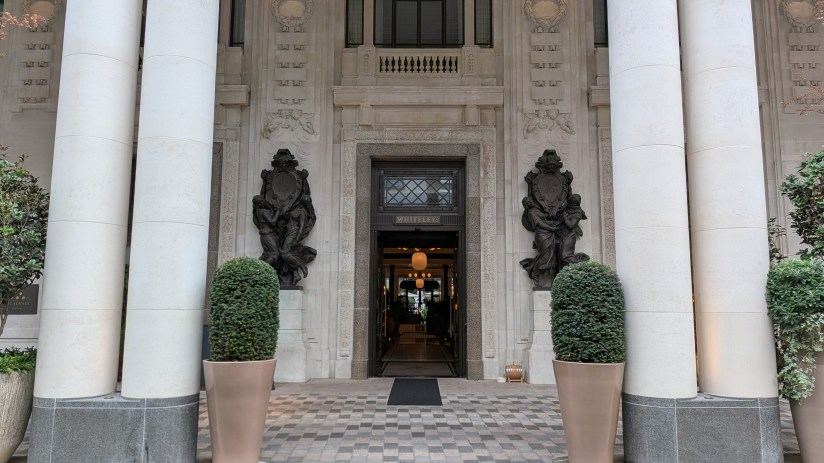 Grand entrance of Six Senses London, featuring ornate stone details, classical columns, and sculptures at Whiteleys.