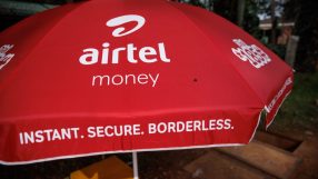 Red Airtel Money umbrella with Instant. Secure. Borderless. slogan, advertising mobile financial services.