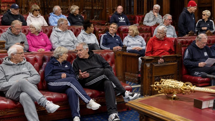 People in tracksuits and casual wear seated in the ornate House of Lords chamber, highlighting a relaxed atmosphere.
