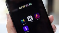 Smartphone displaying financial apps: Monzo, Revolut, Atom, Starling, with credit card and currency icons.