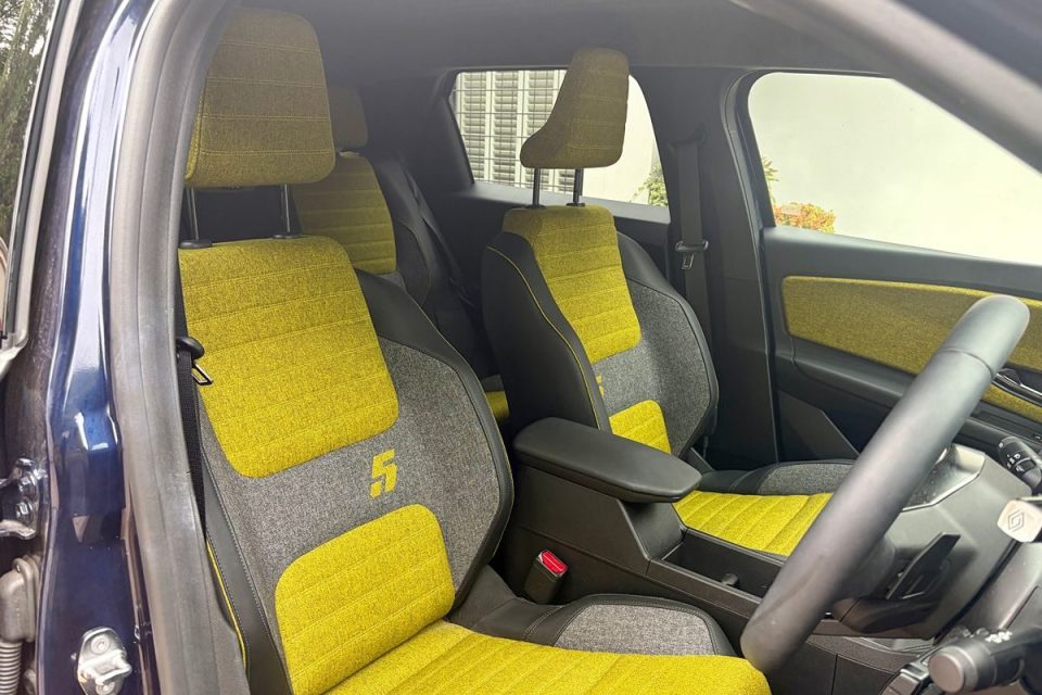 Interior of a car with two-tone yellow and gray fabric seats, steering wheel, and door panel accents.