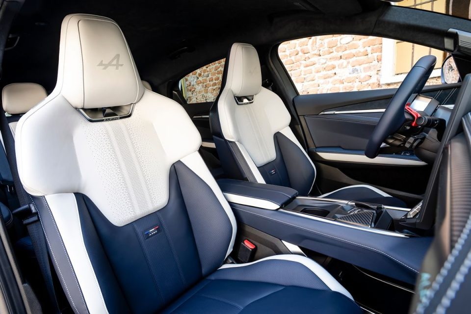Interior of an Alpine A390 concept car with white and blue leather sports seats and a steering wheel