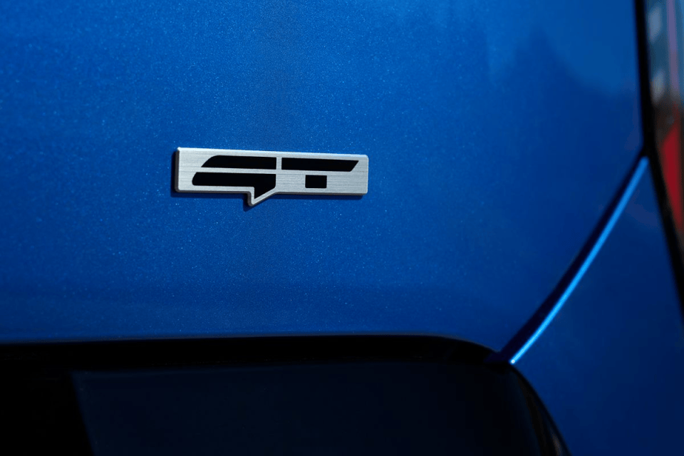 Close-up of a silver ST badge on the blue metallic paint of a cars body panel