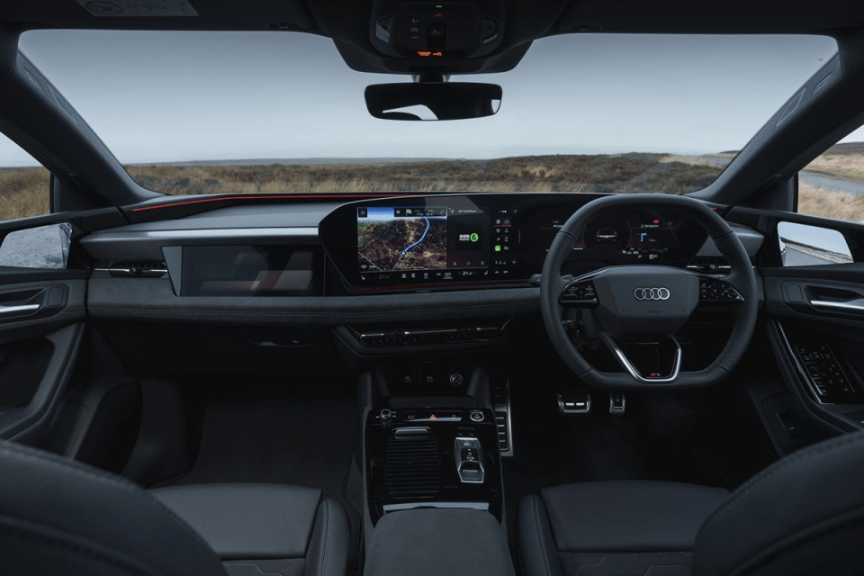 Interior view of an Audi car dashboard with digital screens, steering wheel, and navigation system