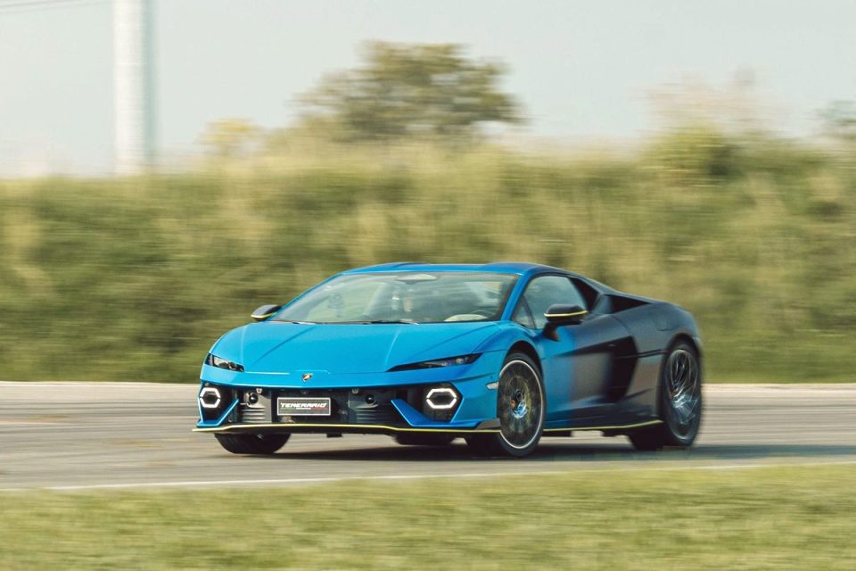 Blue performance sports car driving on a track with motion blur, showcasing speed and design.