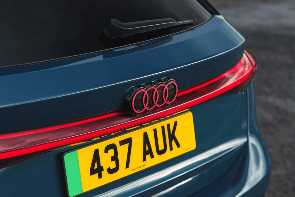 Rear view of a blue Audi car with custom pink rings logo and UK license plate 437 AUK