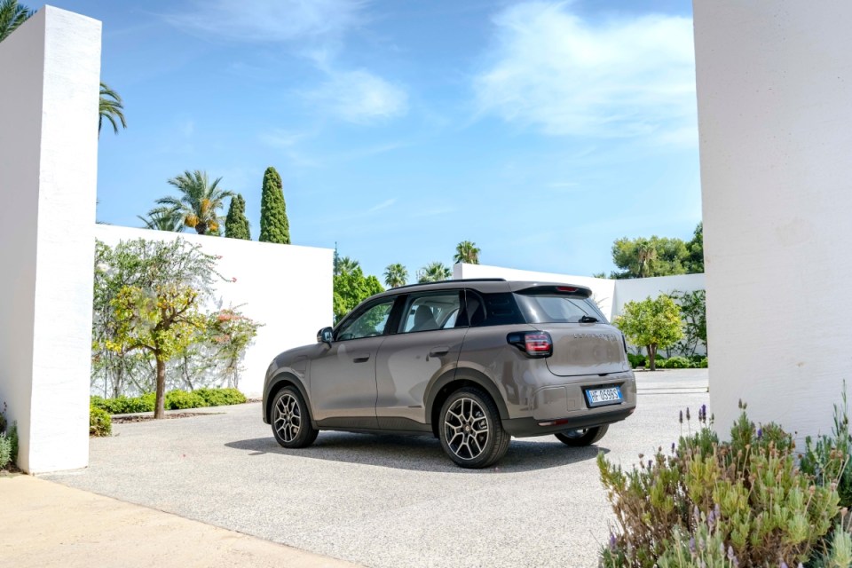 Leapmotor B03X SUV in Acorn Brown parked in a sunny, modern villa driveway with white walls and palm trees.