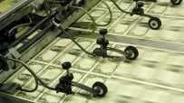 Sheets of newly printed US one-dollar bills moving along a printing press production line.