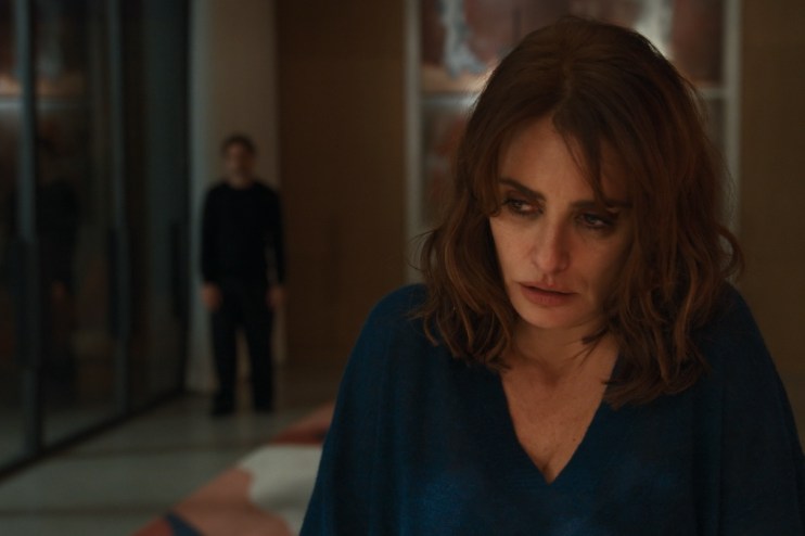 Penélope Cruz with a worried expression, a blurry man in the background, likely from a Venice Film Festival film.