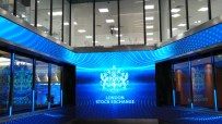 London Stock Exchange logo on a large blue digital display screen in a modern building atrium