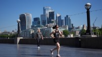 Woman jogging on a promenade with the London skyline, including the Walkie-Talkie building, in the background.