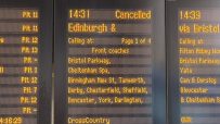 Close-up of a train station departure board showing 14:31 Cancelled for an Edinburgh service.