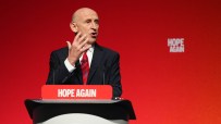 Geoff Hoon speaking at a podium with Hope Again text, against a red background.