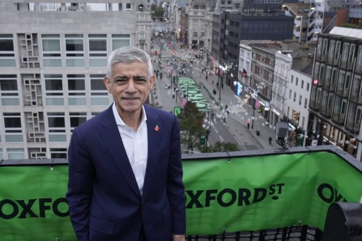 Sadiq Khan overlooking Oxford Street in London, showing the bustling street below and surrounding city buildings.