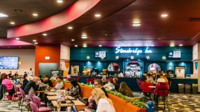 People seated at tables inside a Buzz Bingo hall, with a bar labeled Stonebridge Inn in the background.