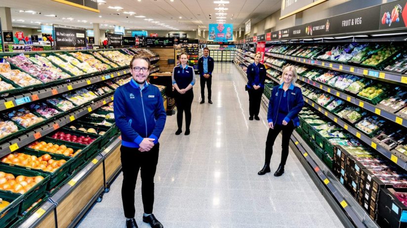 ALDI Sandhurst supermarket with five uniformed staff members in the produce aisle, featuring fresh fruits and vegetables.