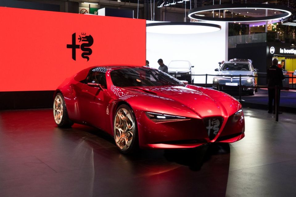 Red Alfa Romeo concept car on display at an auto show with the Alfa Romeo logo visible